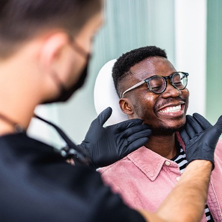 Dentist looking at smiling patient's teeth