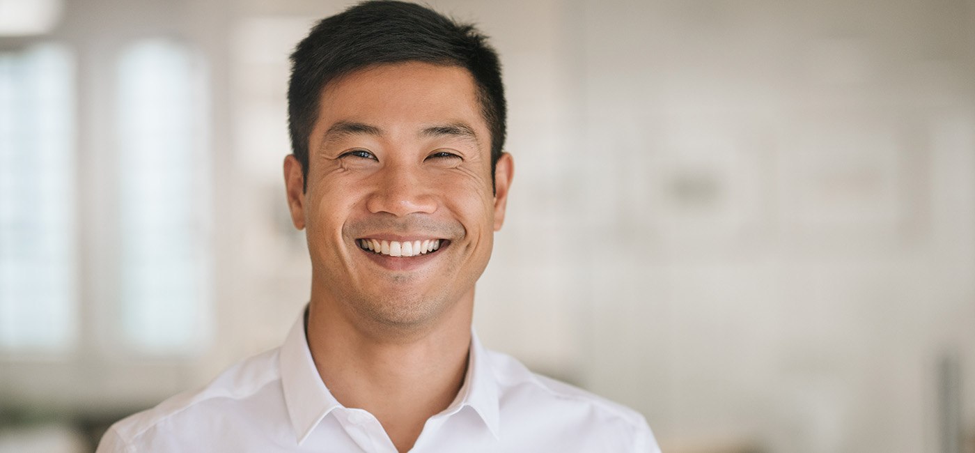 Male professional in white shirt smiling after using in-house membership plan in Altavista 