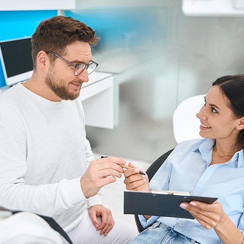 Dental team member talking to patient about membership plan