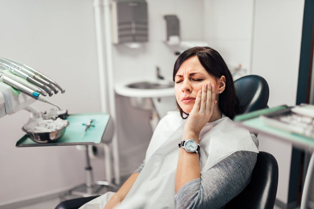 A woman with a toothache sitting in a dentist’s chair