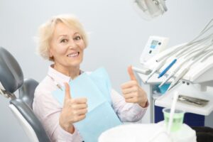 Older woman smiling and holding thumbs up